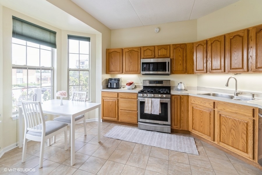 3135 Town Square Drive, Unit 106 Rolling Meadows, IL 60008 - Photo 15 of 20 a kitchen with a stove a sink and a microwave