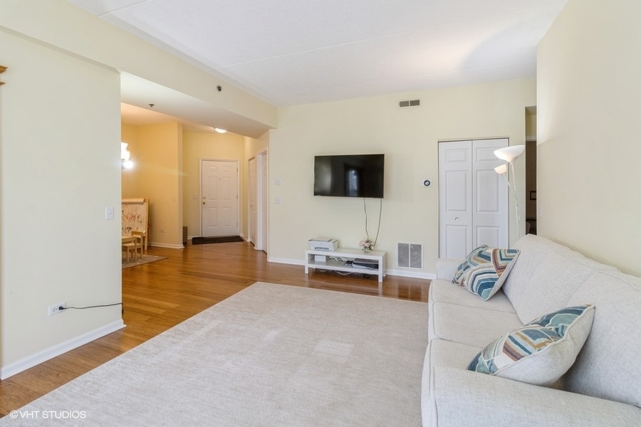 3135 Town Square Drive, Unit 106 Rolling Meadows, IL 60008 - Photo 4 of 20 a living room with furniture and a flat screen tv