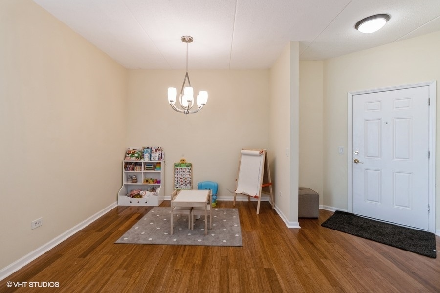 3135 Town Square Drive, Unit 106 Rolling Meadows, IL 60008 - Photo 6 of 20 a view of a room with wooden floor and chair