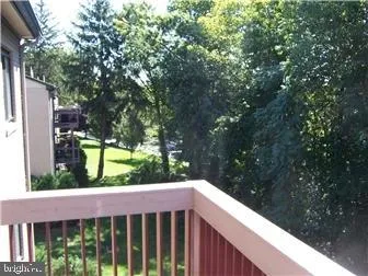 a balcony with wooden floor and yard in the back