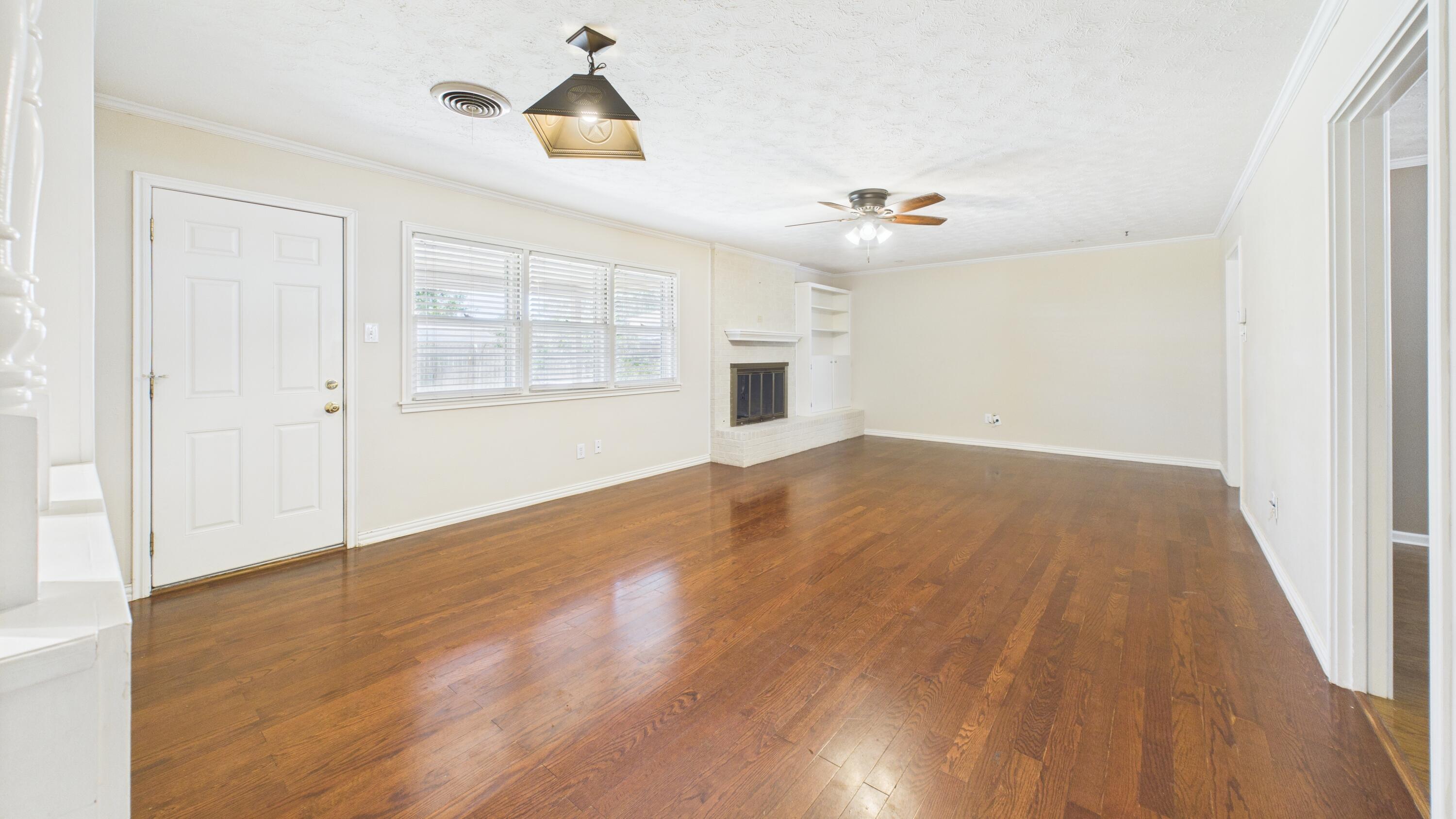 3022 67th Street Lubbock, TX 79413 - Photo 13 of 42 wooden floor in an empty room with a window