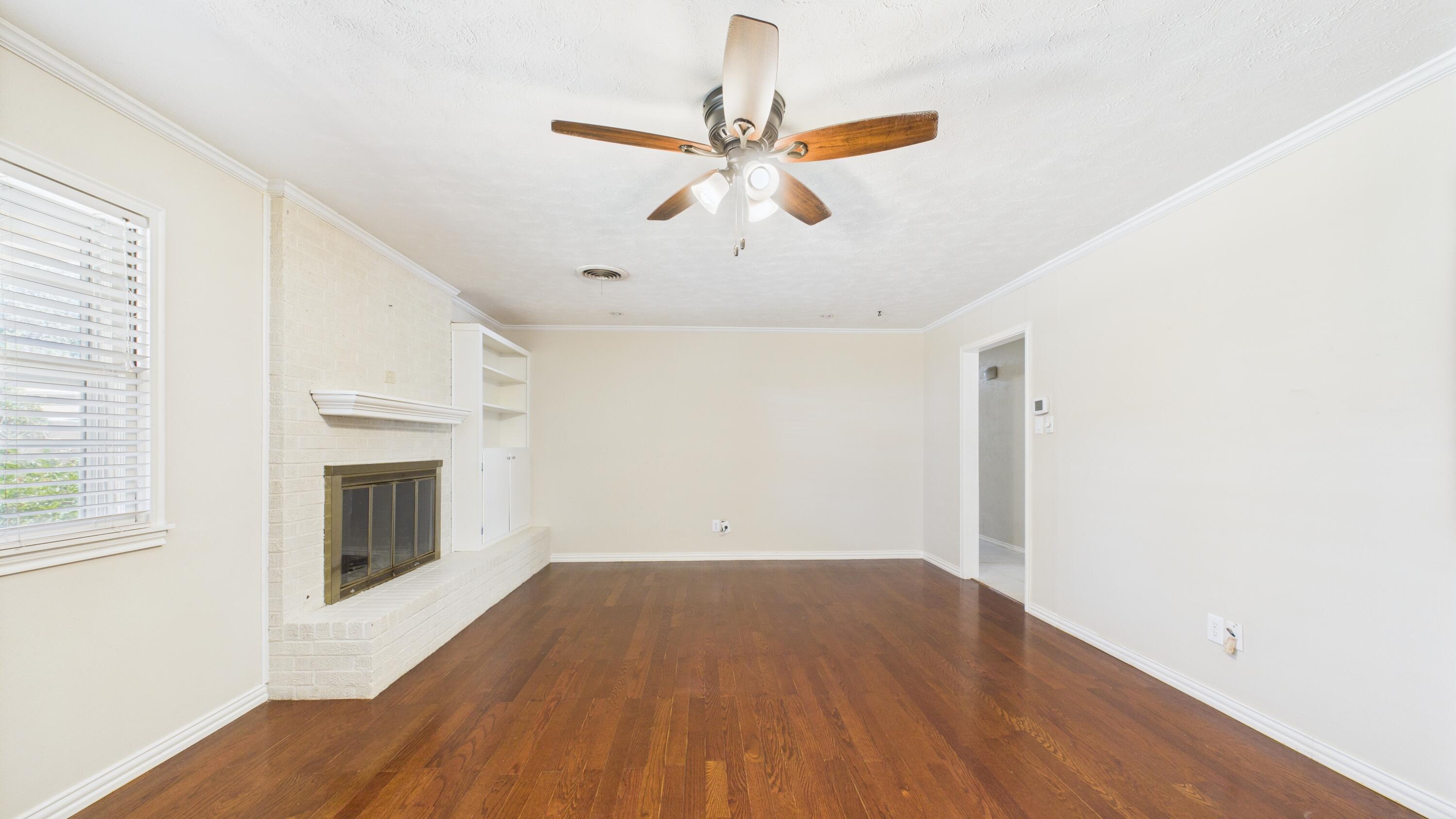3022 67th Street Lubbock, TX 79413 - Photo 14 of 42 a view of empty room with wooden floor and ceiling fan