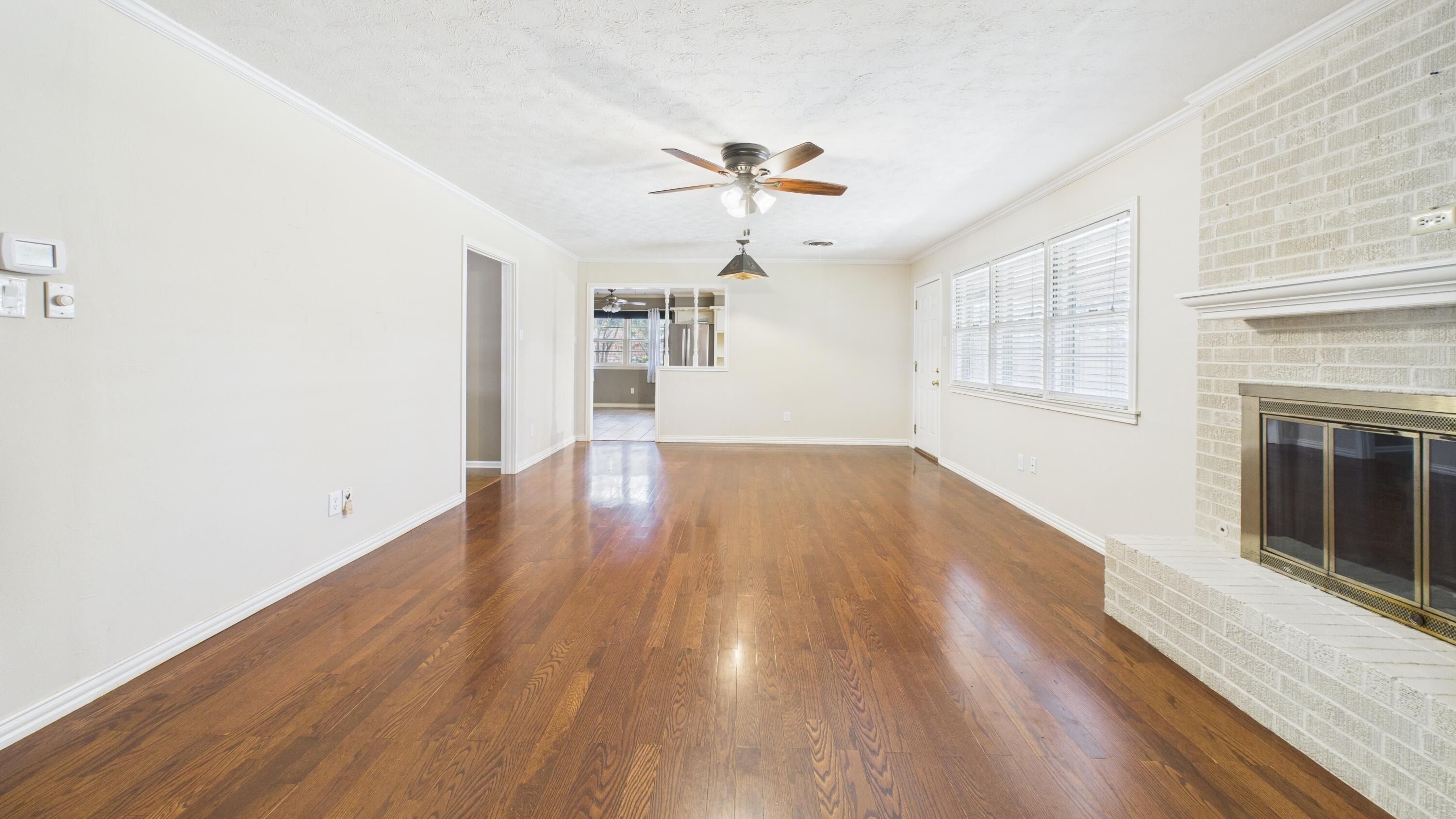 3022 67th Street Lubbock, TX 79413 - Photo 17 of 42 wooden floor in an empty room with a window