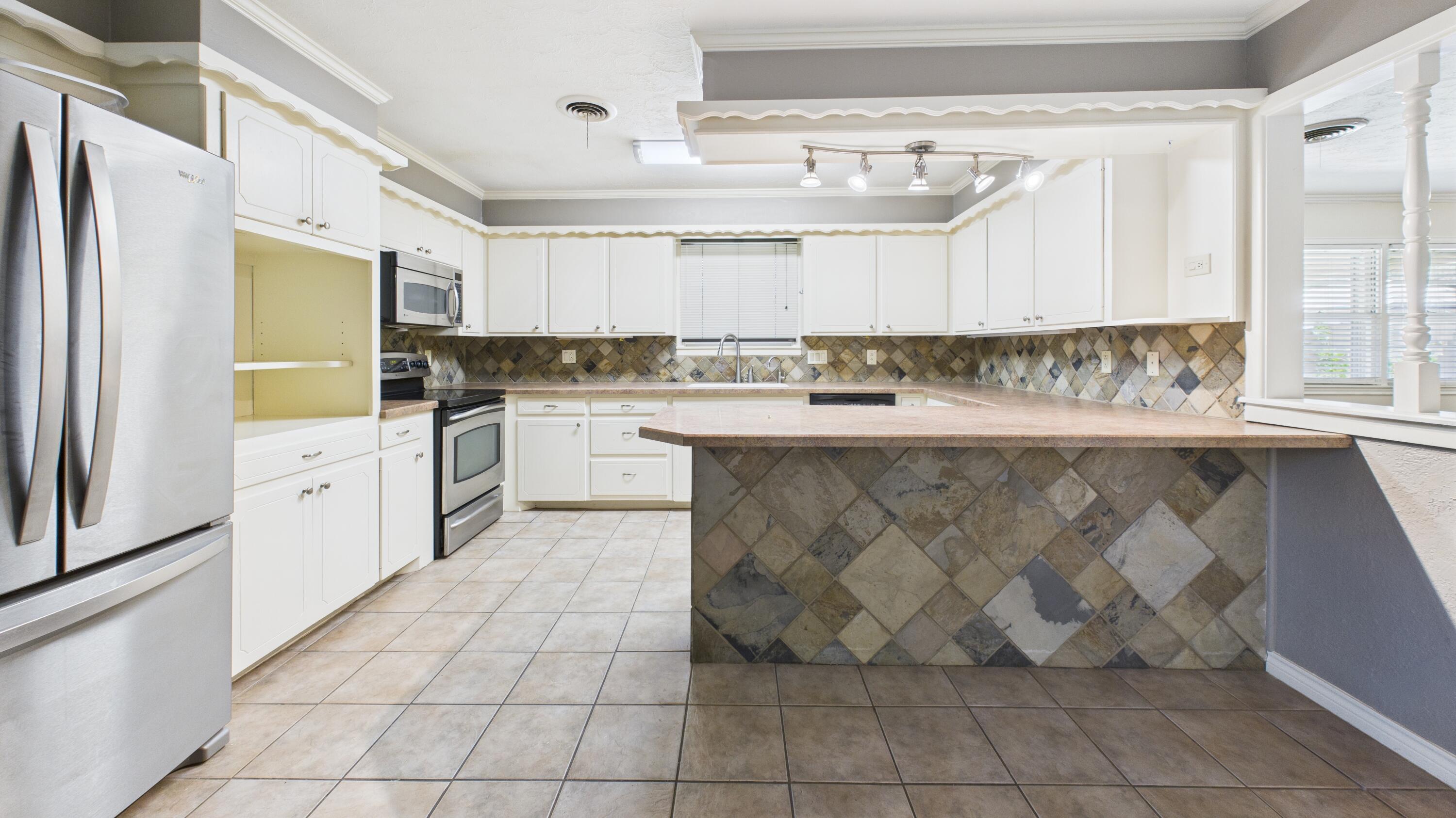 3022 67th Street Lubbock, TX 79413 - Photo 18 of 42 a kitchen with stainless steel appliances granite countertop a sink stove and cabinets