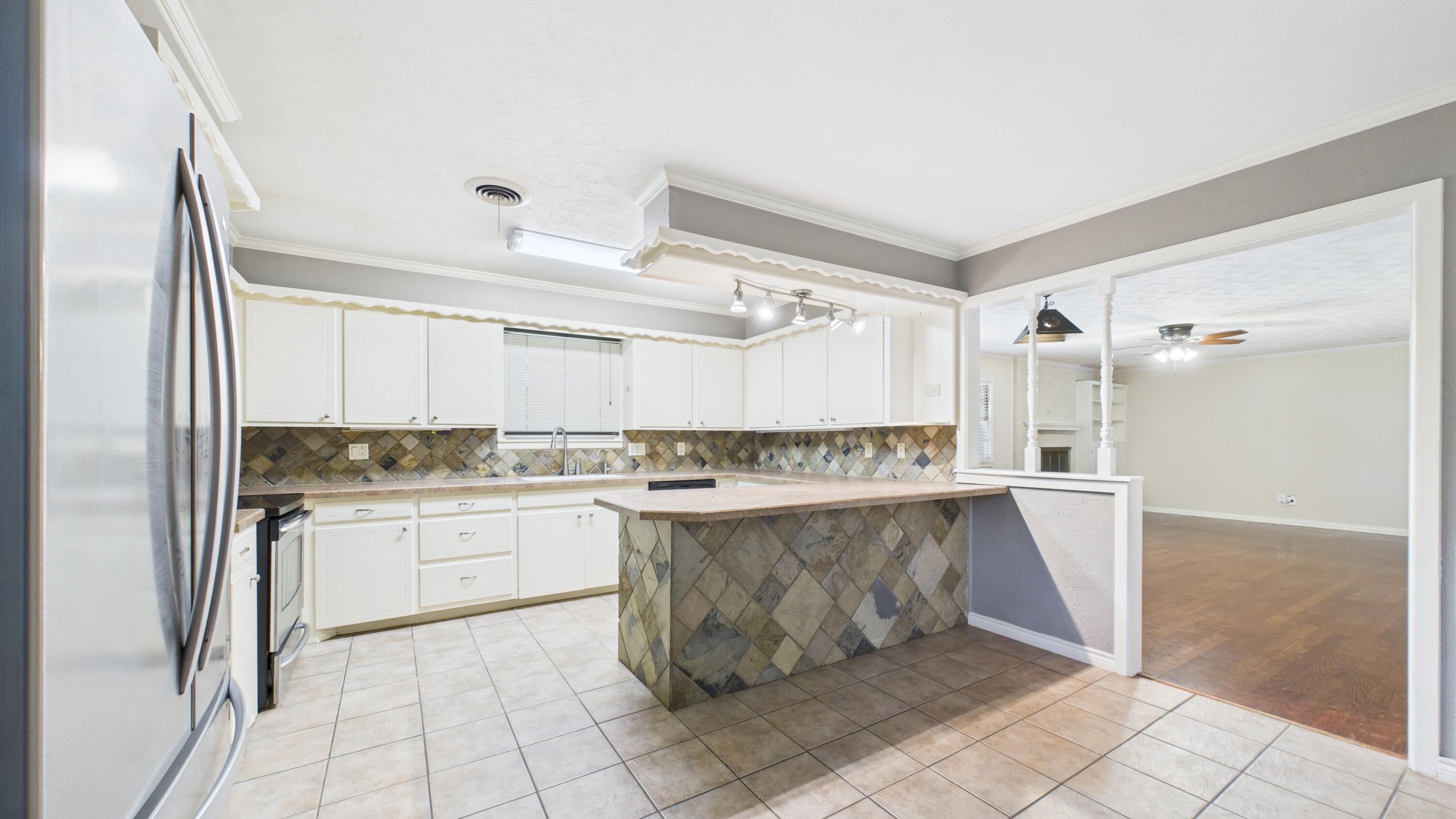 3022 67th Street Lubbock, TX 79413 - Photo 19 of 42 a kitchen with a sink and refrigerator