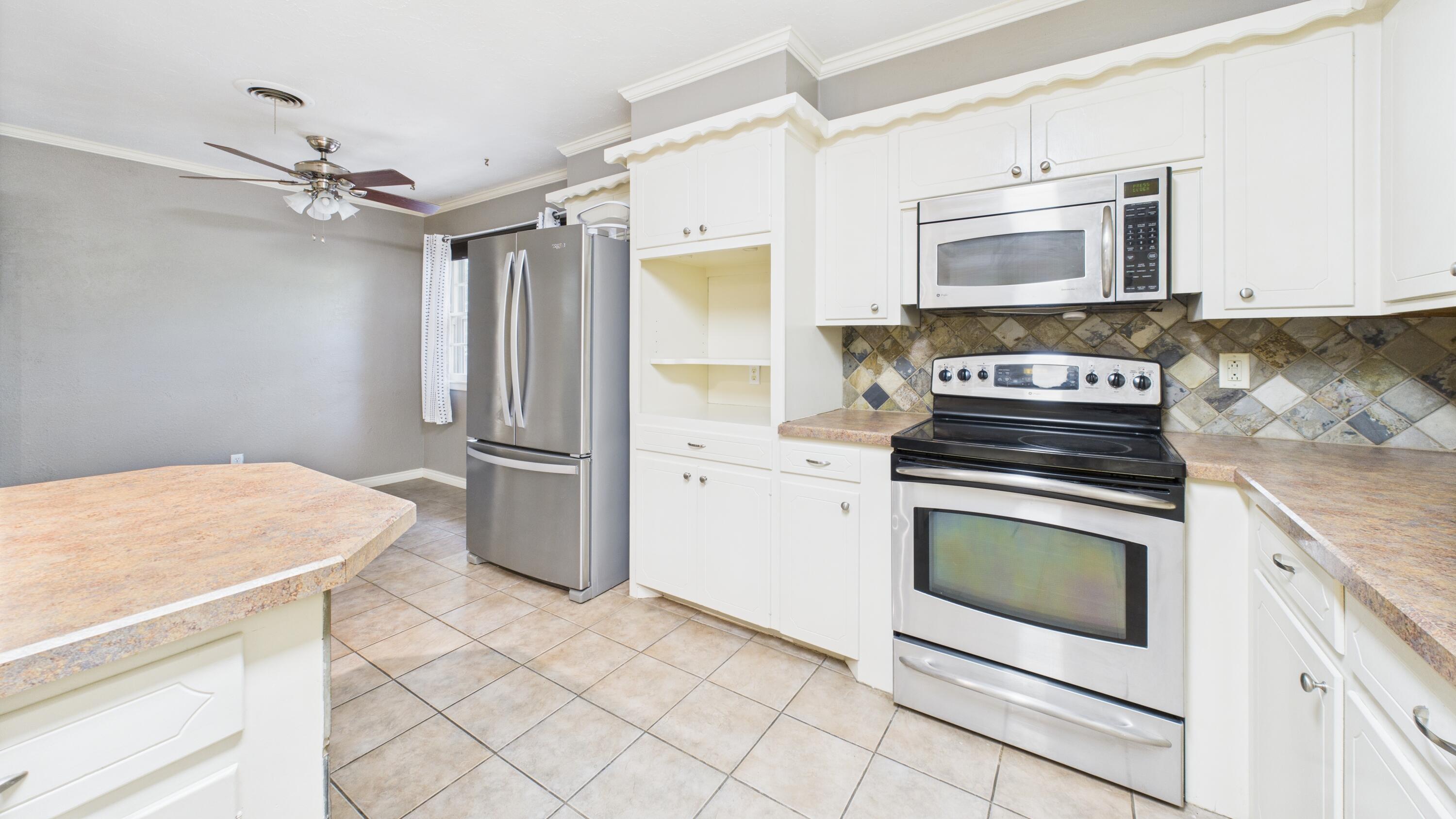 3022 67th Street Lubbock, TX 79413 - Photo 20 of 42 a kitchen with stainless steel appliances a stove microwave and refrigerator