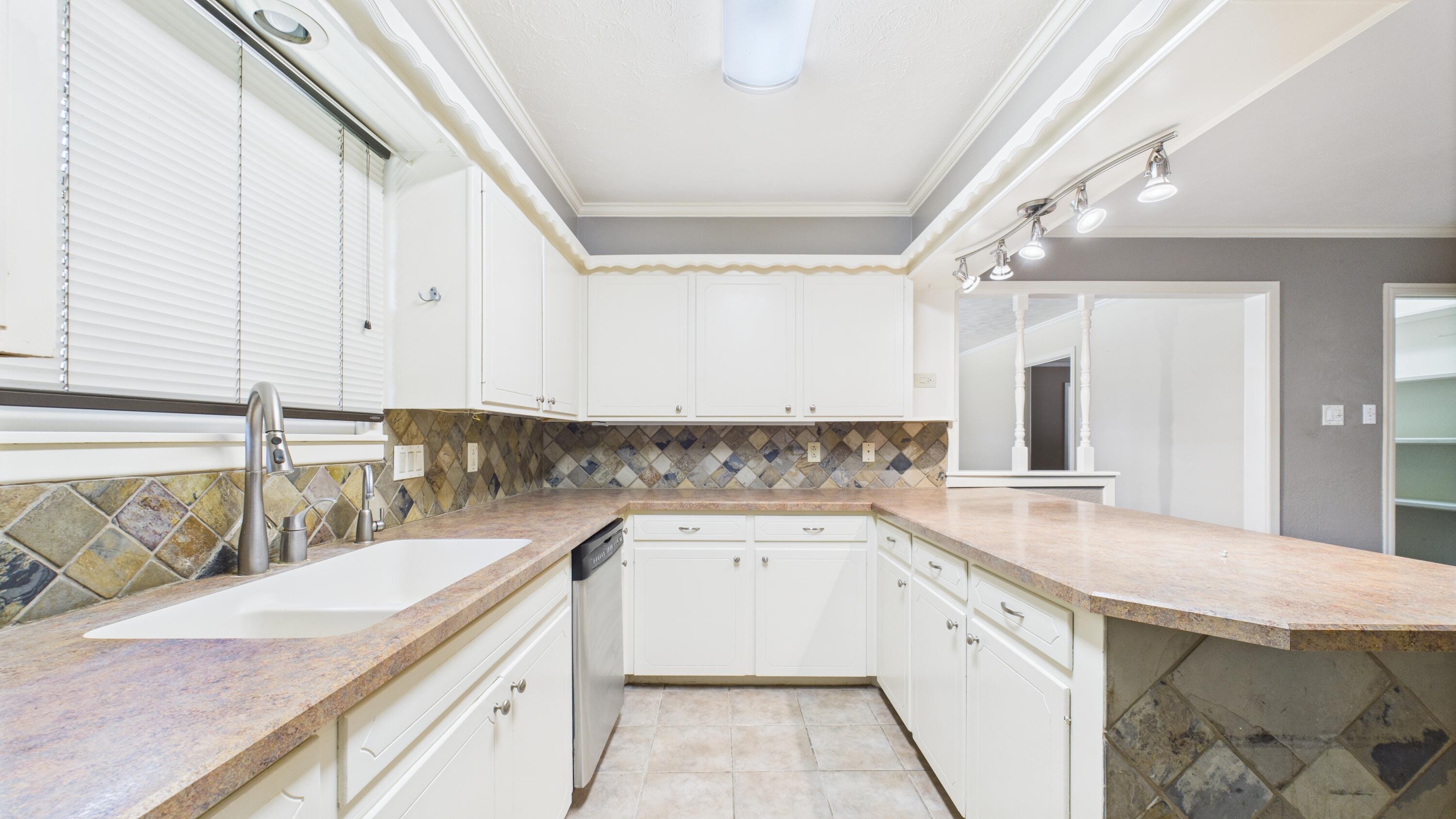 3022 67th Street Lubbock, TX 79413 - Photo 21 of 42 a kitchen with a sink and cabinets