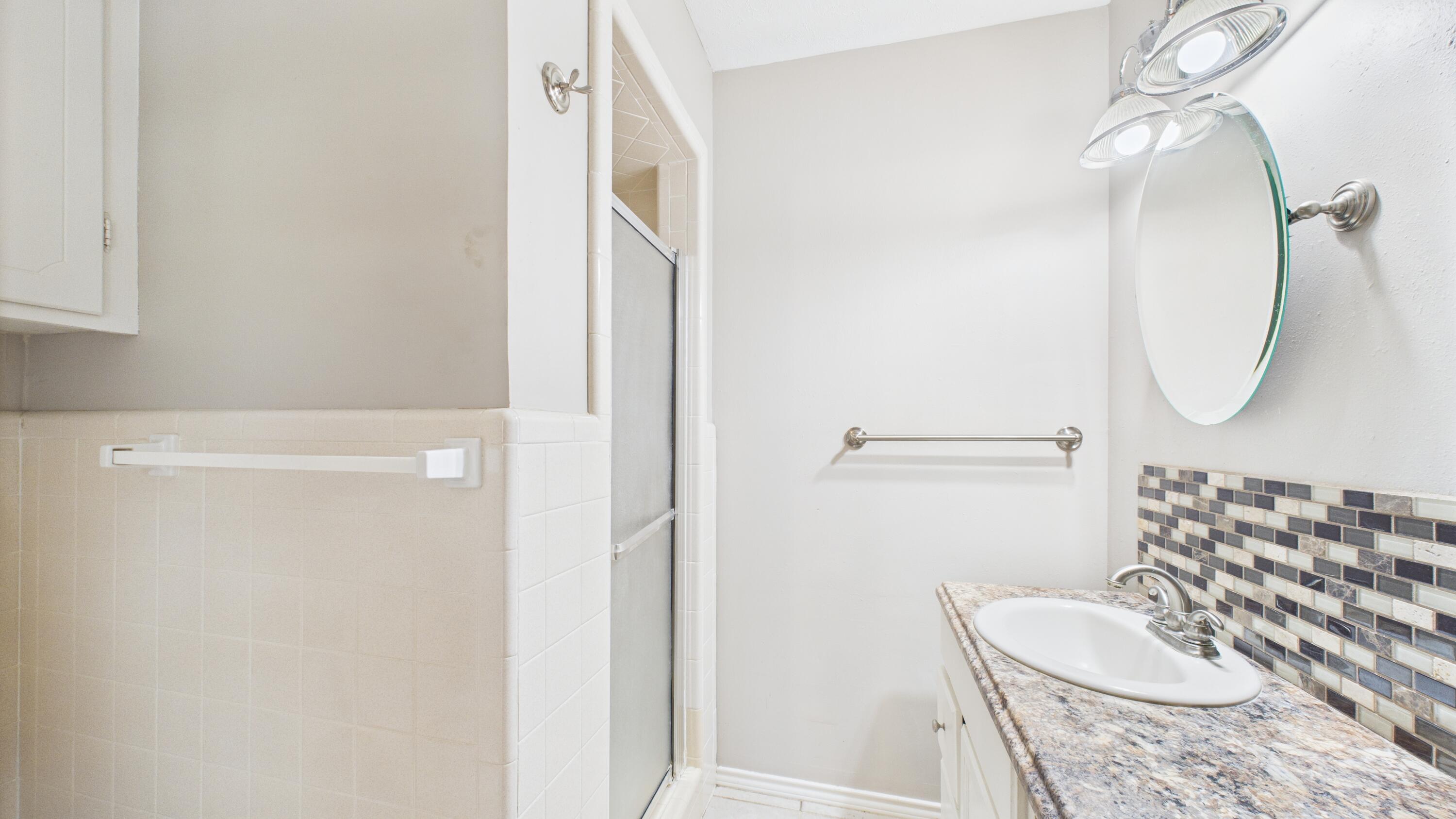 3022 67th Street Lubbock, TX 79413 - Photo 30 of 42 a bathroom with a sink toilet and mirror