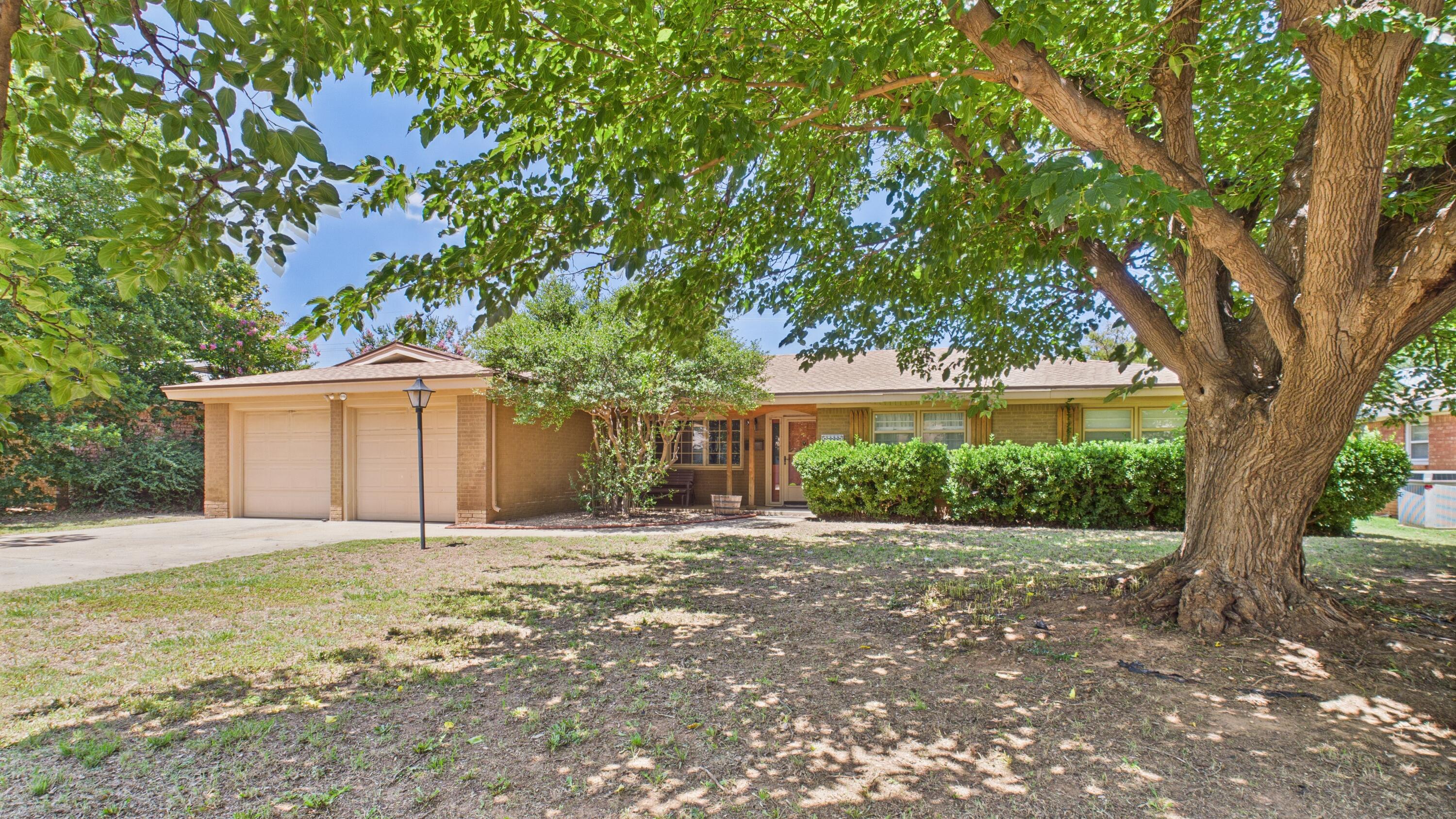 3022 67th Street Lubbock, TX 79413 - Photo 3 of 42 a front view of a house with a yard and trees