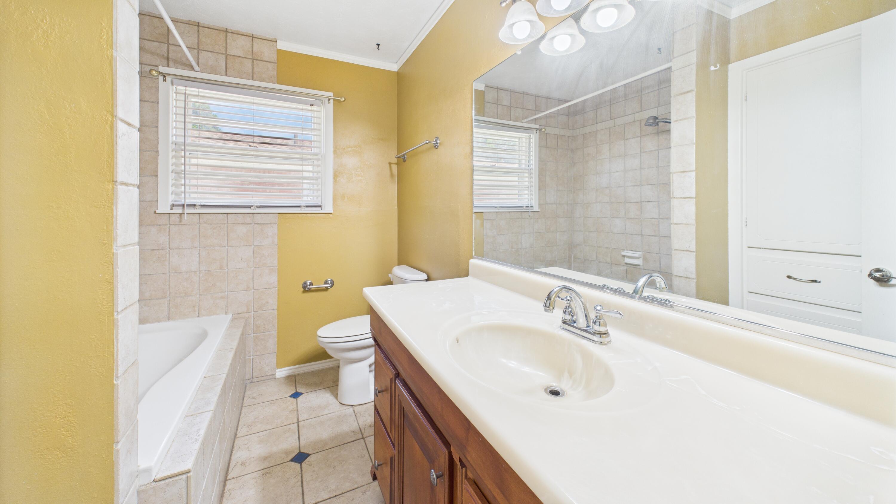 3022 67th Street Lubbock, TX 79413 - Photo 35 of 42 a bathroom with a sink a toilet and shower