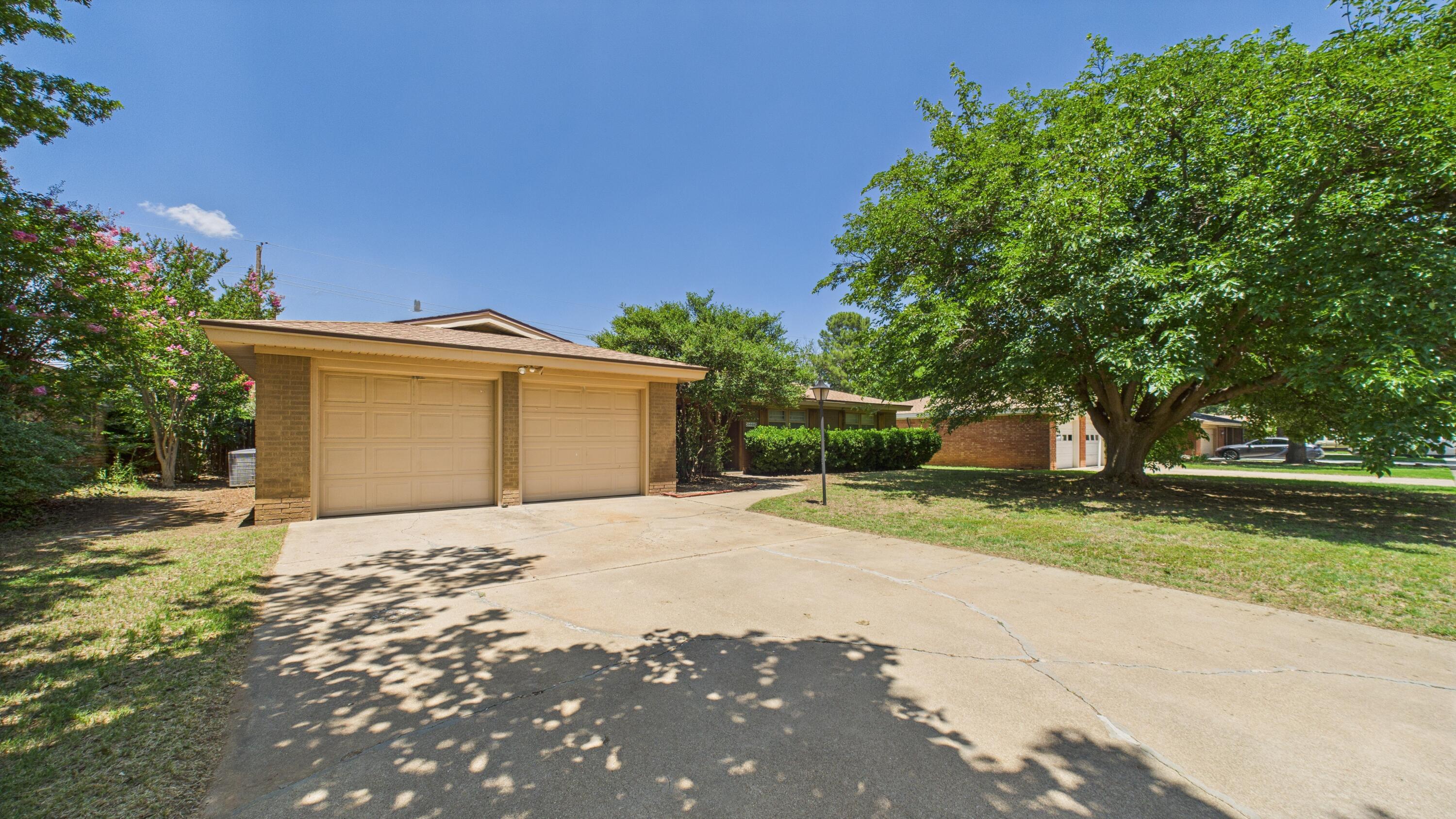 3022 67th Street Lubbock, TX 79413 - Photo 4 of 42 a front view of a house with a yard and garage
