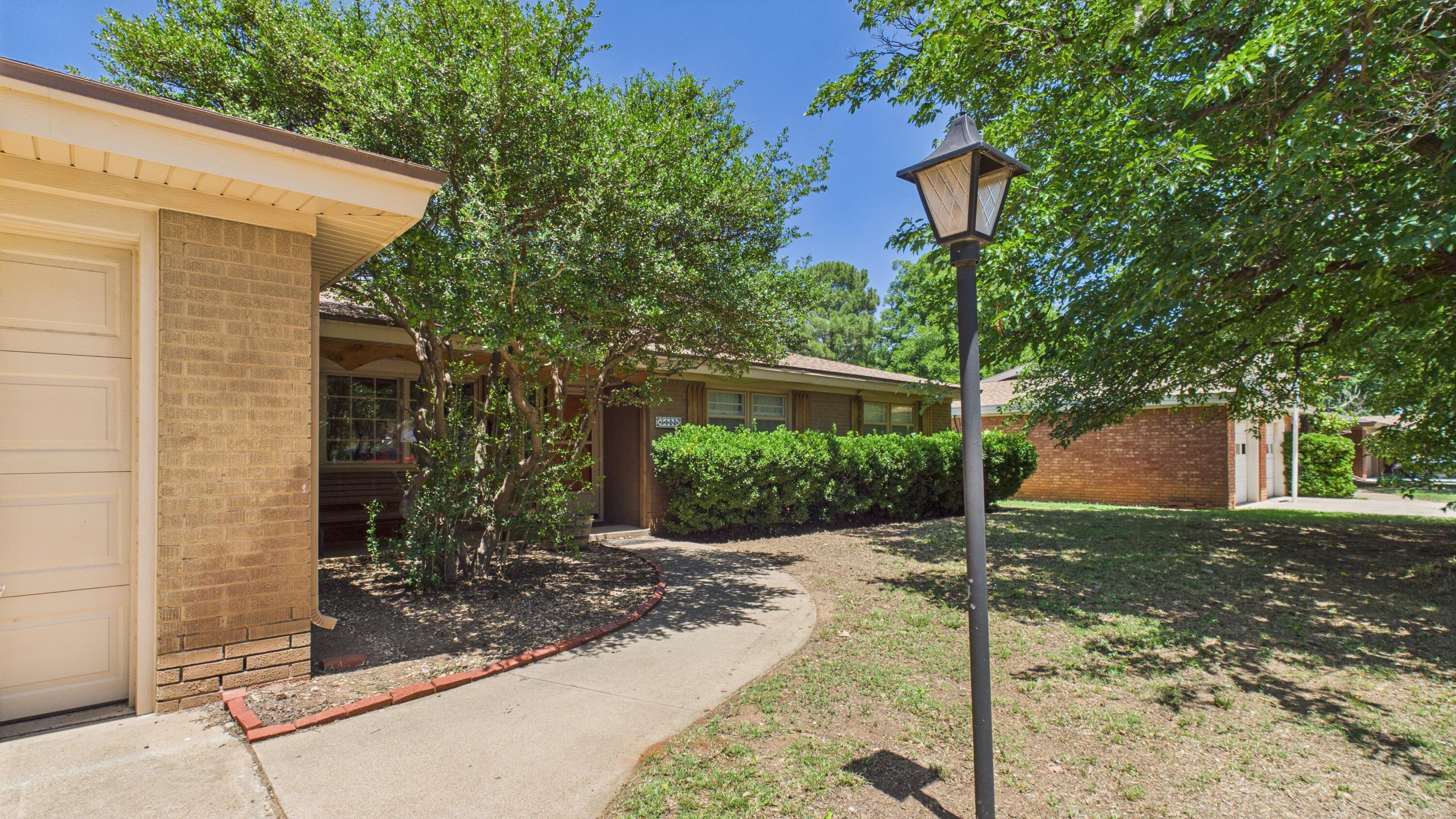 3022 67th Street Lubbock, TX 79413 - Photo 6 of 42 a front view of a house with a yard and tree
