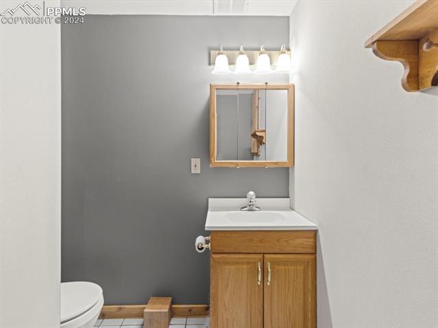 7590 Julynn Road Colorado Springs, CO 80919 - Photo 15 of 44 Bathroom with toilet, vanity, and tile patterned floors