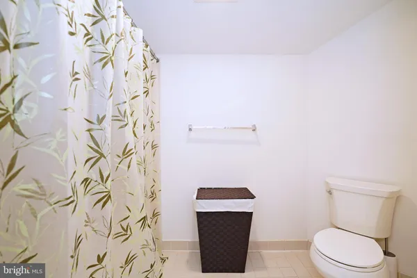 a white toilet sitting next to a shower curtain