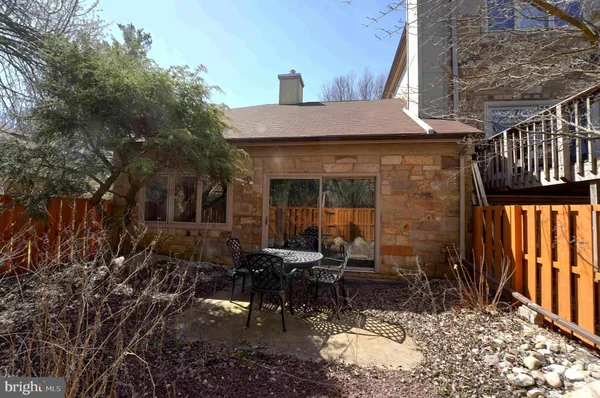 a view of a patio with table and chairs and wooden fence