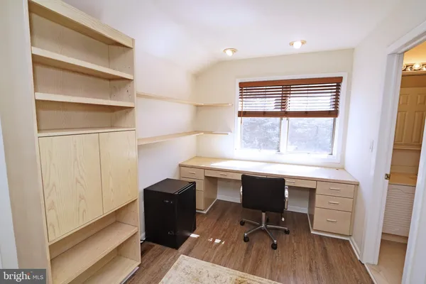 a view of a workspace with furniture and a window