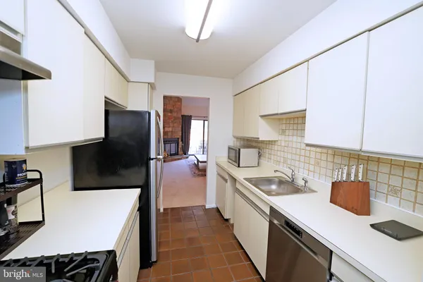 a kitchen with a sink a counter top space stainless steel appliances a sink and cabinets