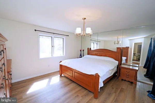 a spacious bedroom with a bed and a chandelier