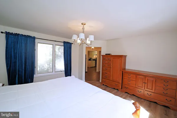 a bedroom with a bed and dresser with mirror