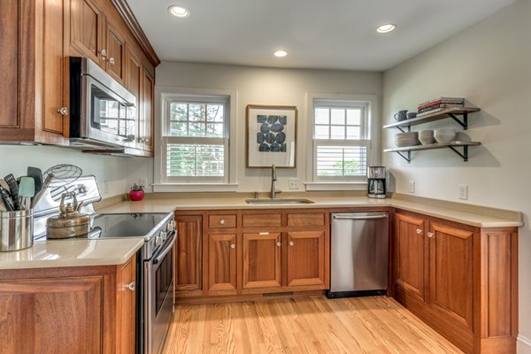832 Webster Street Needham, MA 02492 - Photo 11 of 28 a kitchen with stainless steel appliances granite countertop a sink dishwasher and wooden cabinets with wooden floor