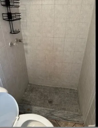 a bathroom with a toilet and a shower