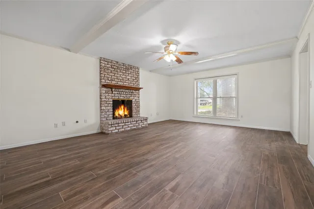 an empty room with windows and fireplace