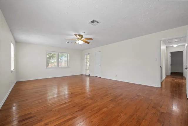 an empty room with wooden floor and window