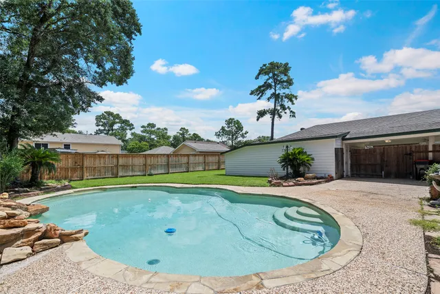 a view of a swimming pool with a patio and plants