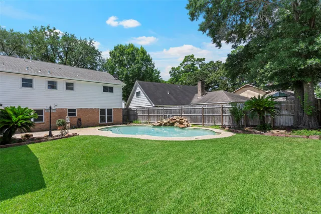 a view of a house with swimming pool and a yard