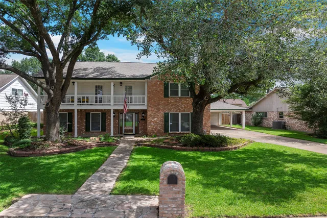 a front view of a house with a yard and trees