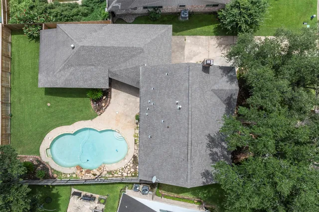 an aerial view of a house with outdoor space and tennis court