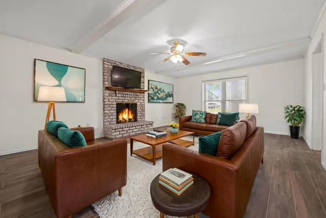 a living room with furniture a flat screen tv and a fireplace