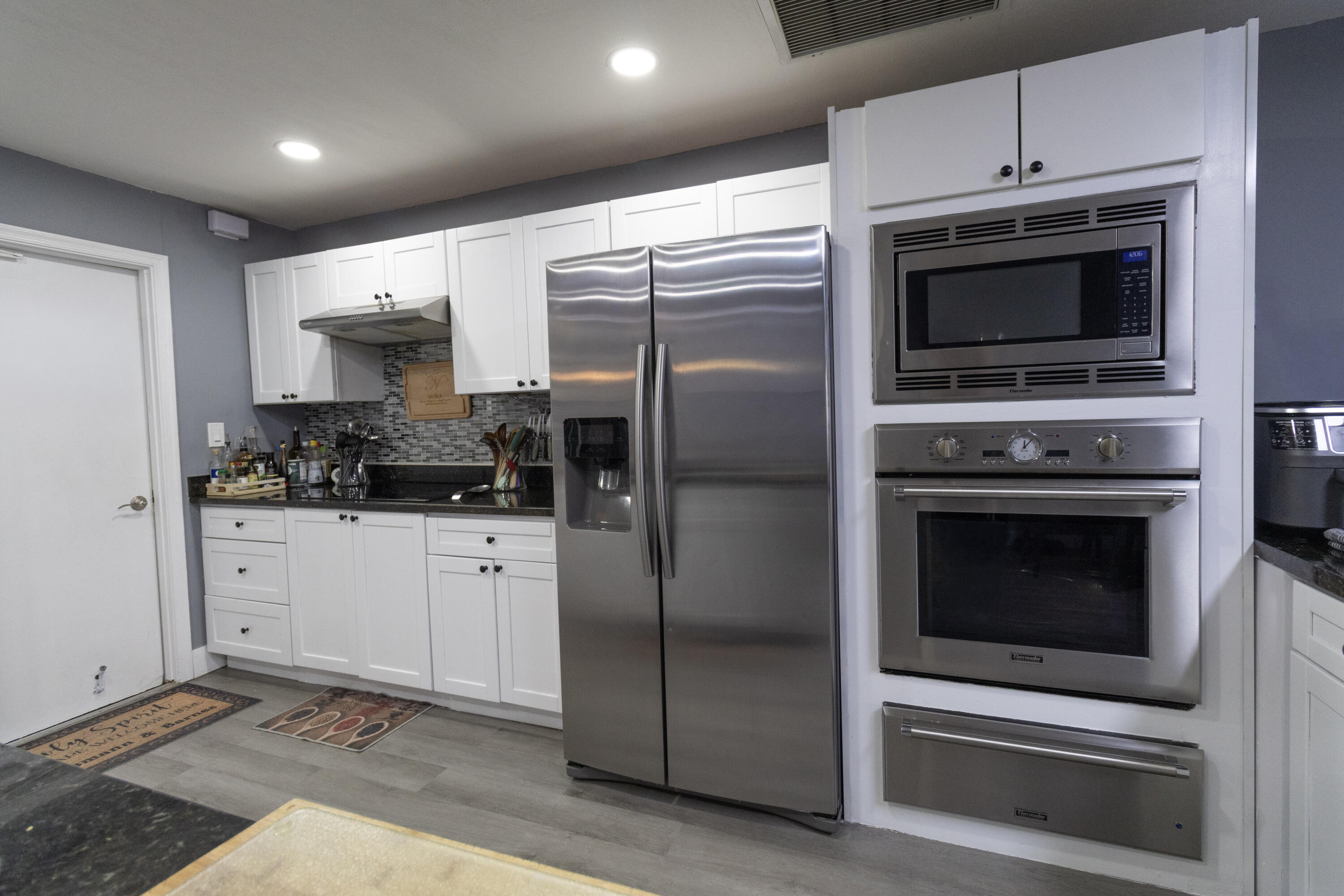 23287 Southwest 60th Avenue Boca Raton, FL 33428 - Photo 25 of 43 a kitchen with stainless steel appliances a stove a microwave and a refrigerator