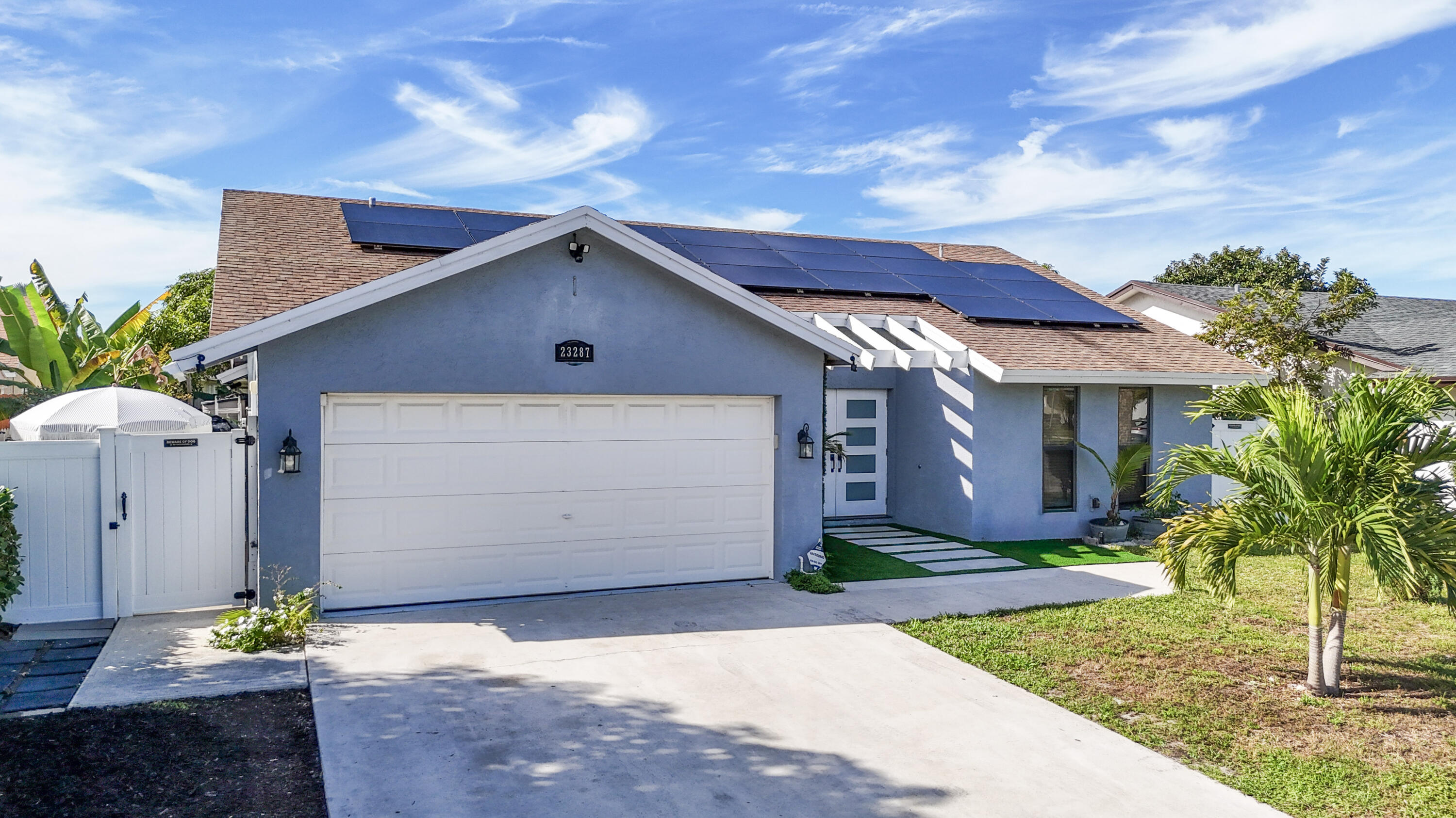 23287 Southwest 60th Avenue Boca Raton, FL 33428 - Photo 3 of 43 a front view of house with yard and trees in the background