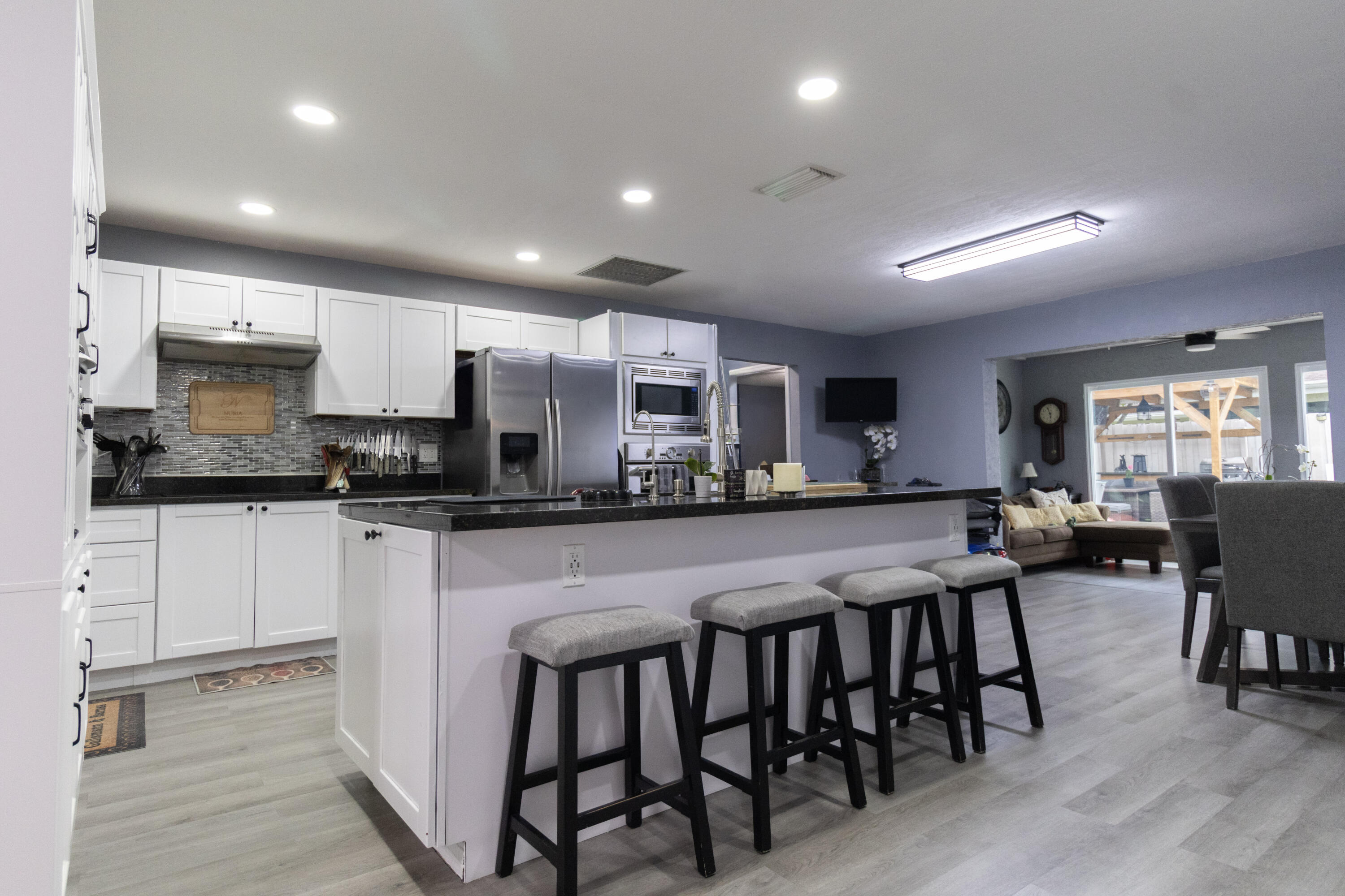 23287 Southwest 60th Avenue Boca Raton, FL 33428 - Photo 8 of 43 a kitchen with stainless steel appliances granite countertop table chairs sink and cabinets