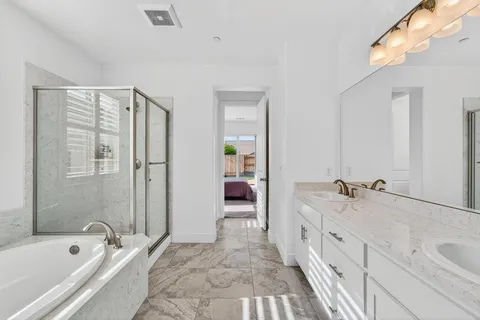 a spacious bathroom with a tub sink and mirror