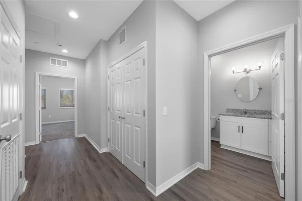 a view of a bathroom from a hallway with wooden floor