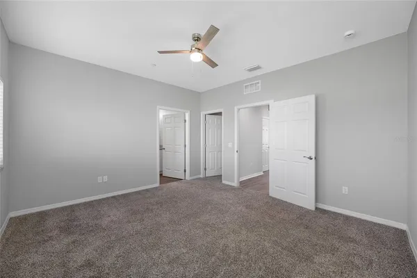 a view of an empty room with a ceiling fan