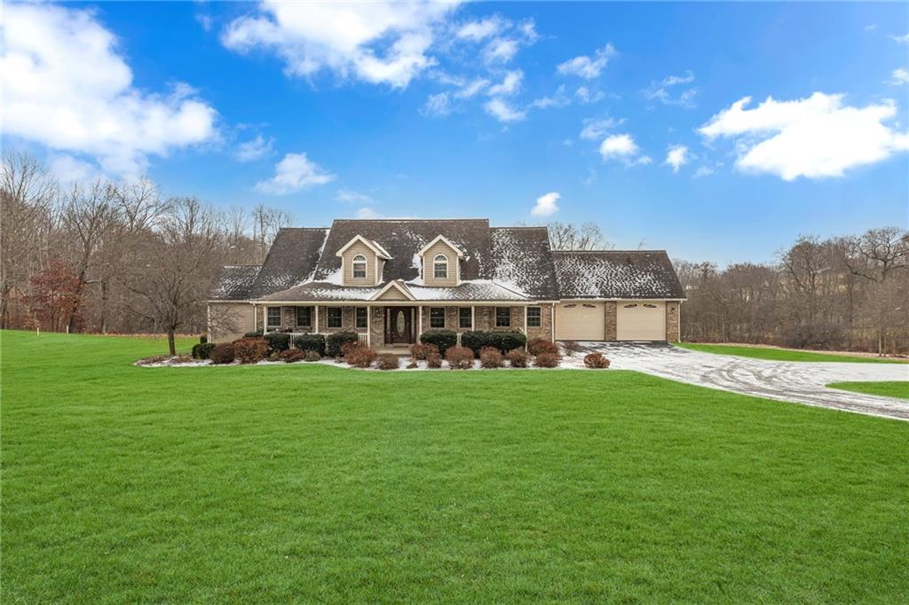 a view of a big house with a big yard and large trees