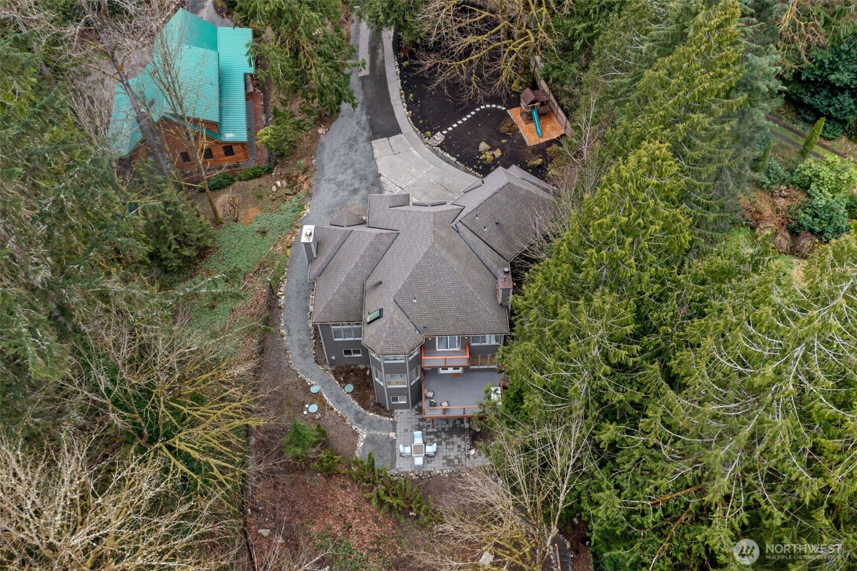 an aerial view of a house with a yard and trees