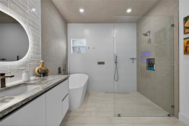 a bathroom with a granite countertop sink a toilet and shower