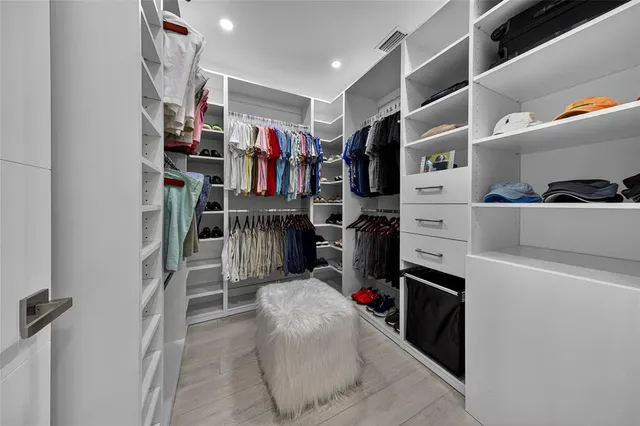 a view of walk in closet with clothes and shoes