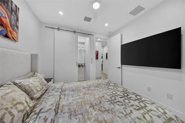 a bedroom with a bed and a flat screen tv