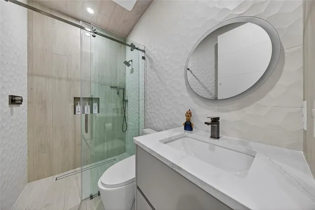 a bathroom with a sink a toilet and shower