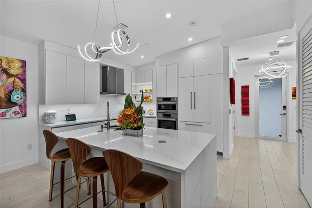 a kitchen with stainless steel appliances a table chairs and a refrigerator