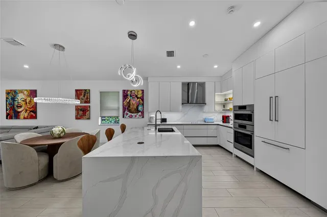 a kitchen with stainless steel appliances kitchen island a refrigerator sink and cabinets