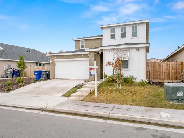 a front view of a house with garden and garage