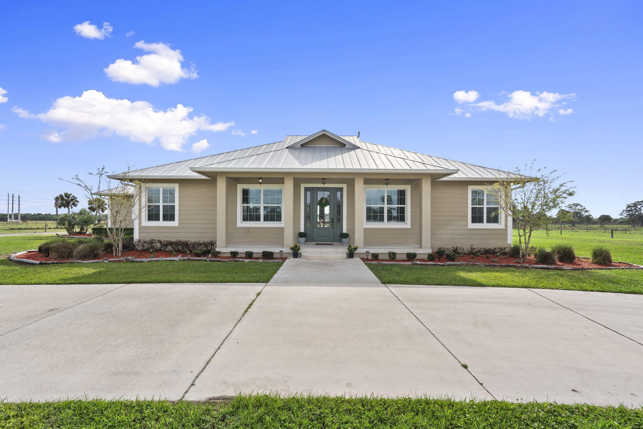 1720 South Brocksmith Road Fort Pierce, FL 34945 - Photo 5 of 53 a front view of a house with a yard and garage