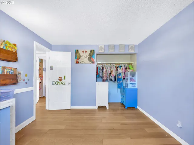 a view of a storage & utility room with fridge and wooden floor