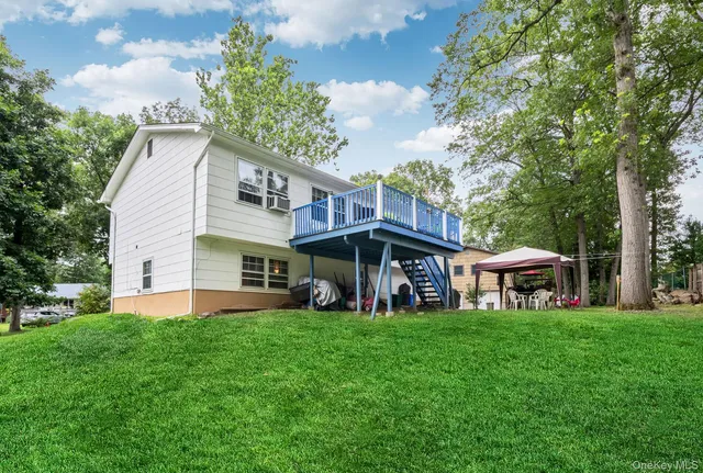 a view of a house with a big yard and large trees
